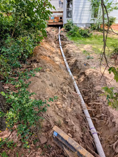Drain line installation by Diamond State Plumbing showing PVC pipe in excavated trench