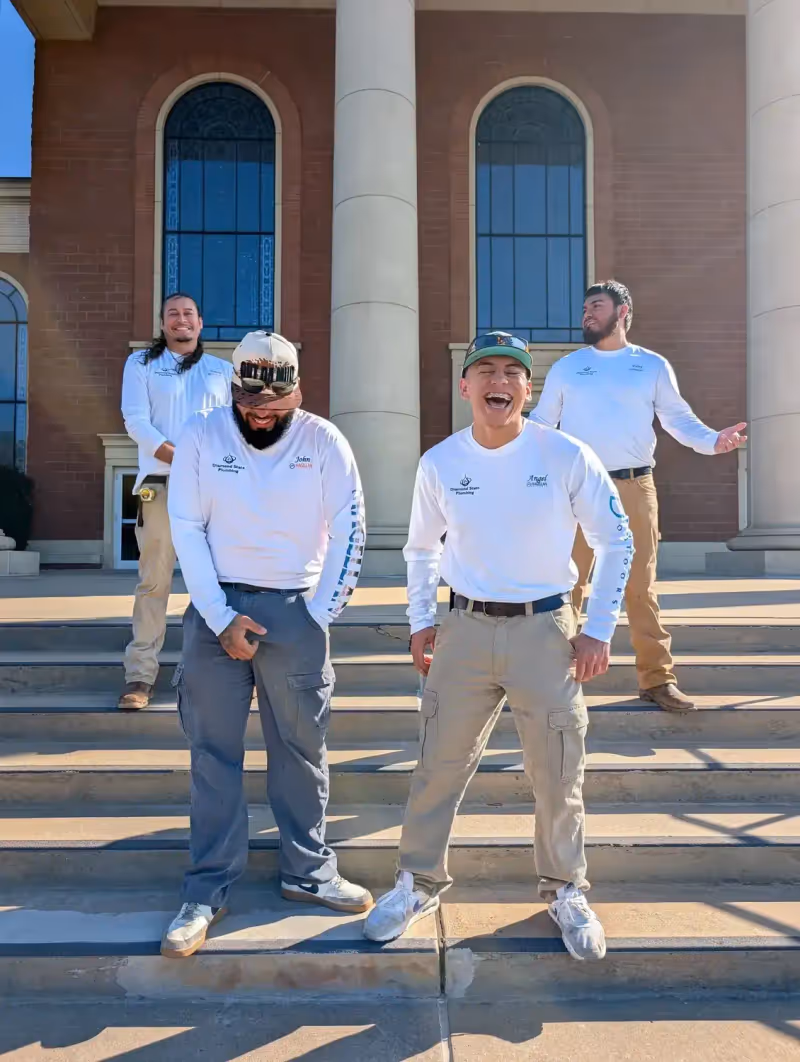 Diamond State Plumbing crew standing on steps of brick building