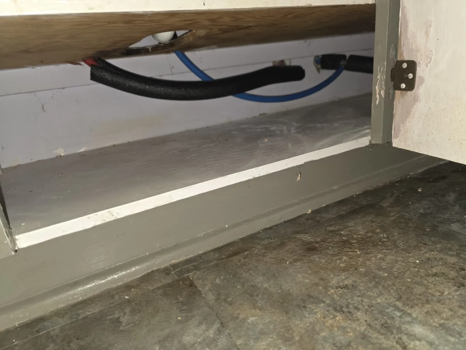 New insulated water supply lines installed behind a cabinet base during a repipe