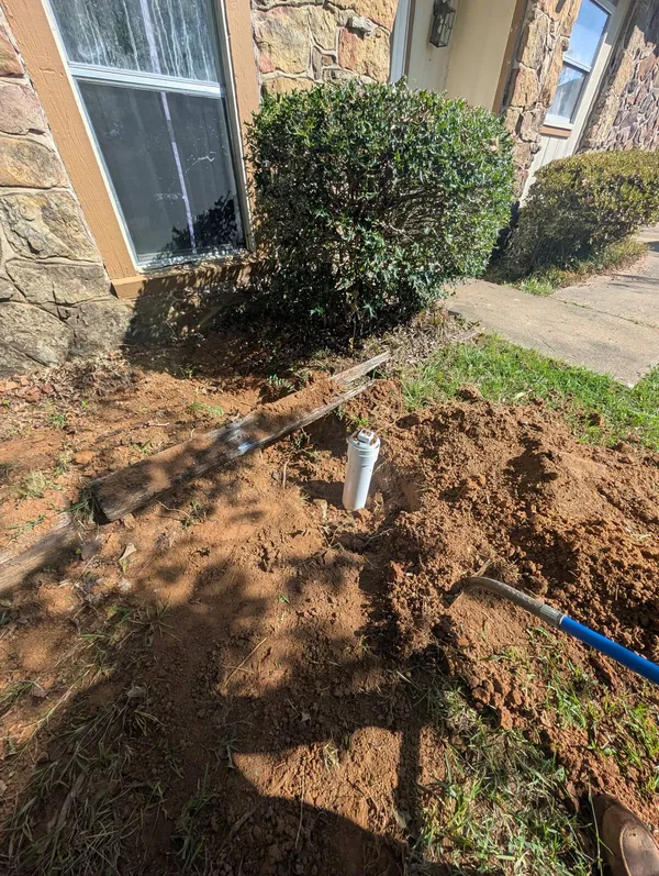 New sewer cleanout installed in the front yard of a brick home
