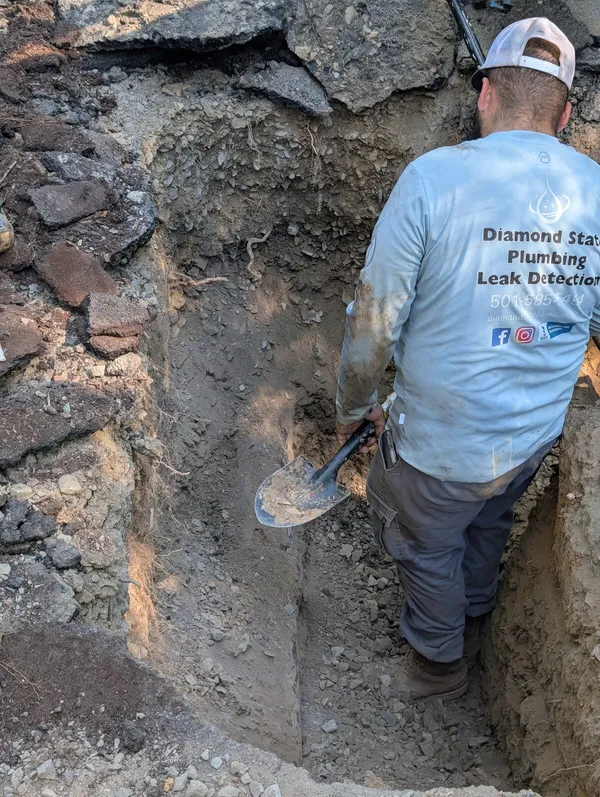 Diamond State Plumbing Leak Detection technician digging out a trench to reach a sewer line