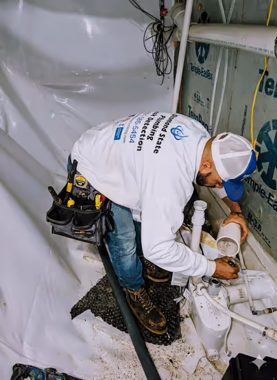Diamond State Plumbing technician installing drain pipes for a toilet rough-in