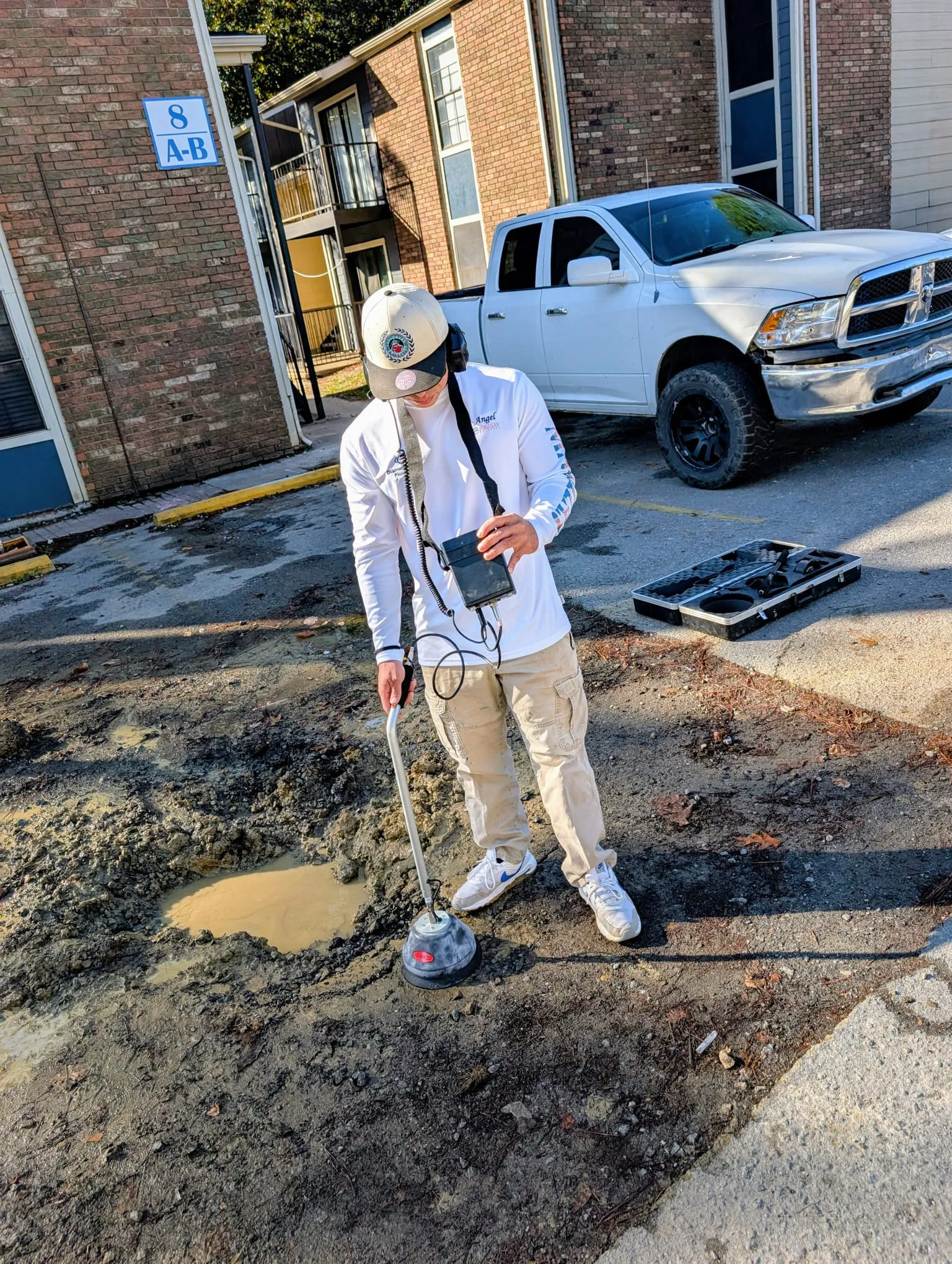 Diamond State Plumbing plumber using an acoustic leak detector over a wet patch of ground
