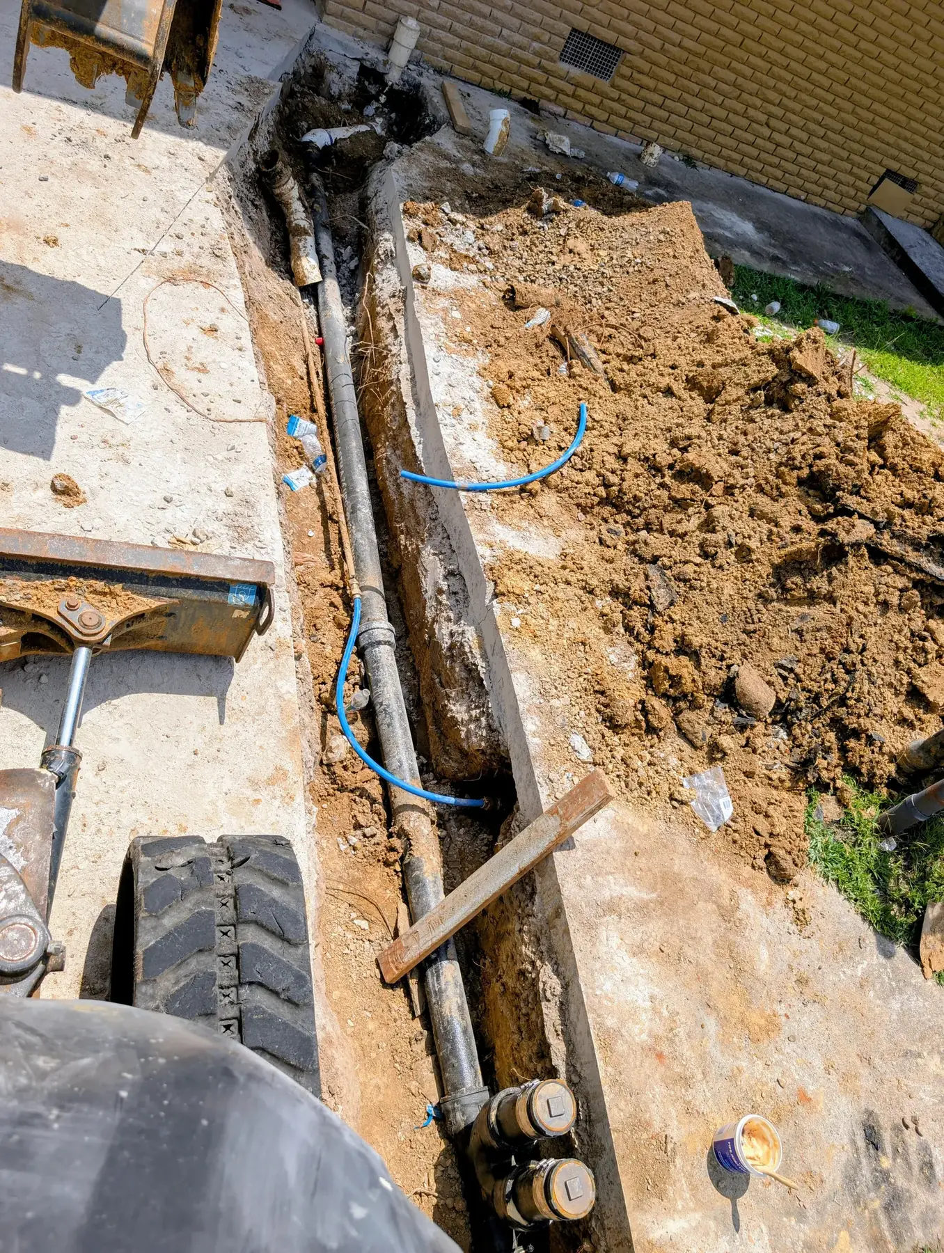 Excavated trench with old and new water service lines