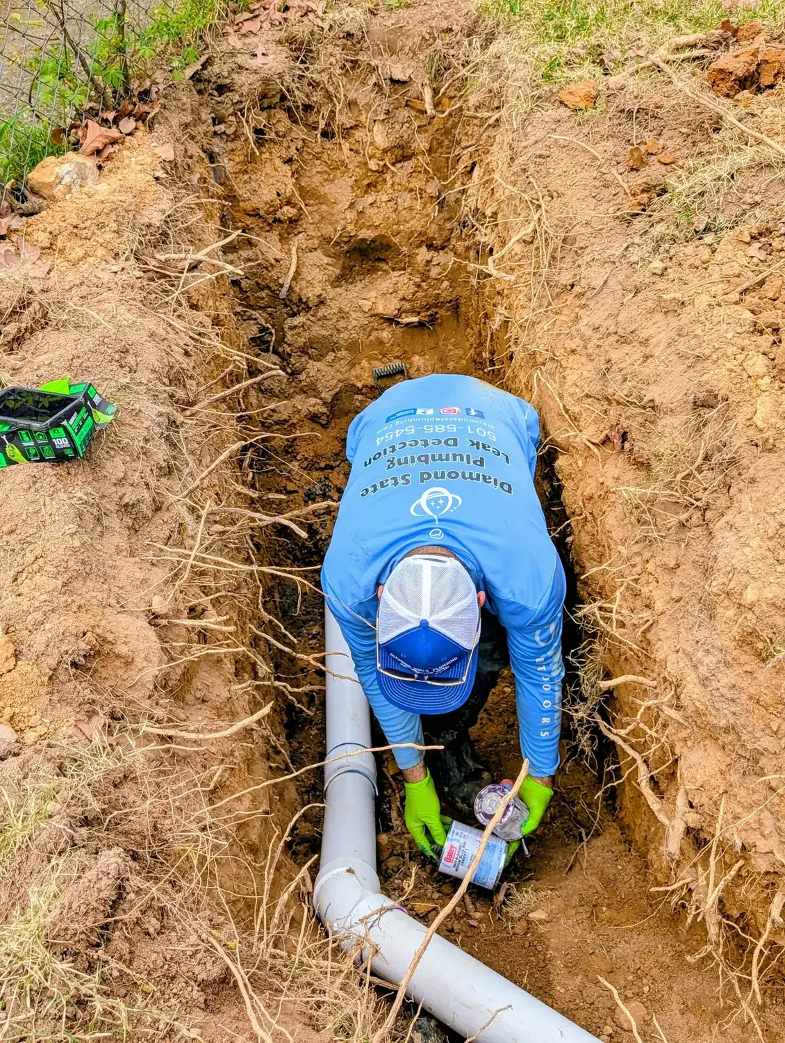 Diamond State Plumbing technician connecting PVC drain pipes underground